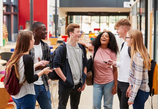 Standing students sharing a happy joke