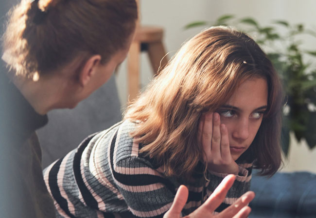Moody teenager being talked to by an adult