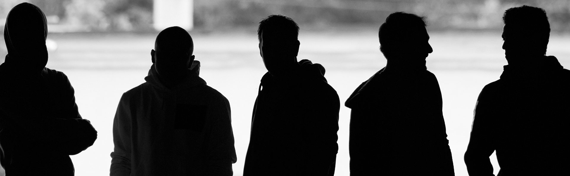 Silhouettes of young people standing in a row